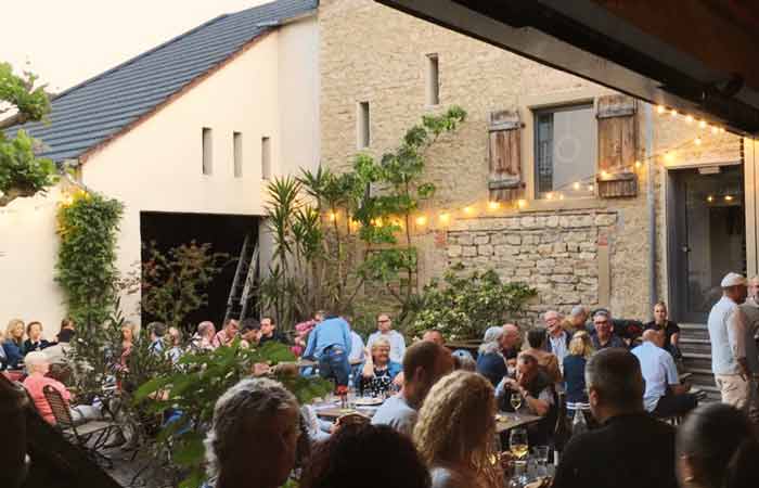 Gäste genießen einen Sommerabend beim Hoffest des Weingut Karl Sonntag.