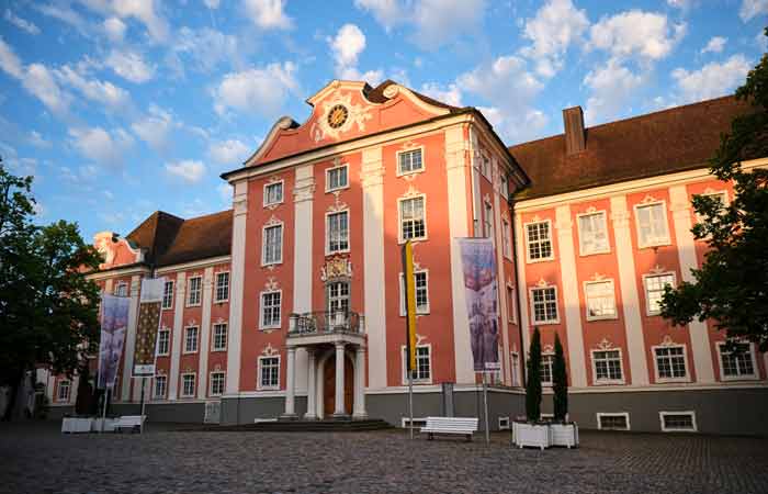 Barockes Neues Schloss in Meersburg mit rosa Fassade und blauem Himmel im Hintergrund.