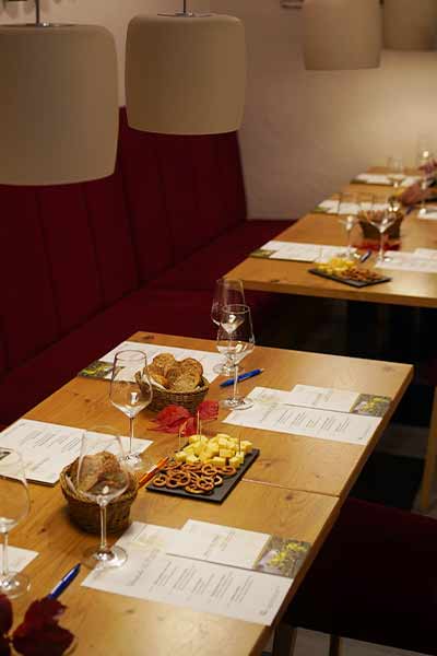 Stimmungsvoll beleuchtetes Ambiente im Weingut Hahn – ein liebevoll gedeckter Tisch für die Weinprobe mit Baguette, Snacks und Weingläsern.