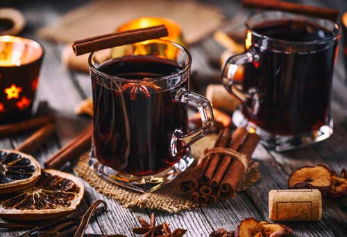 Zwei Tassen Glühwein mit weihnachtlicher dekoration.