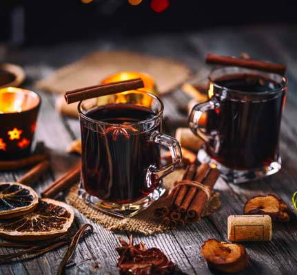 Zwei Tassen Glühwein mit weihnachtlicher dekoration.