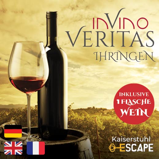 Rotwein und Weinglas stehen auf einem Holzfass in den Weinreben vor einem Sonnenuntergang.